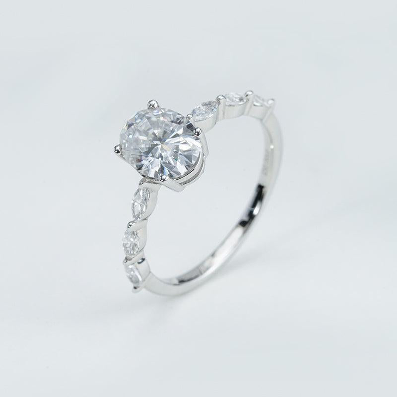 Silver ring with a large diamond and smaller diamonds on a light gray background