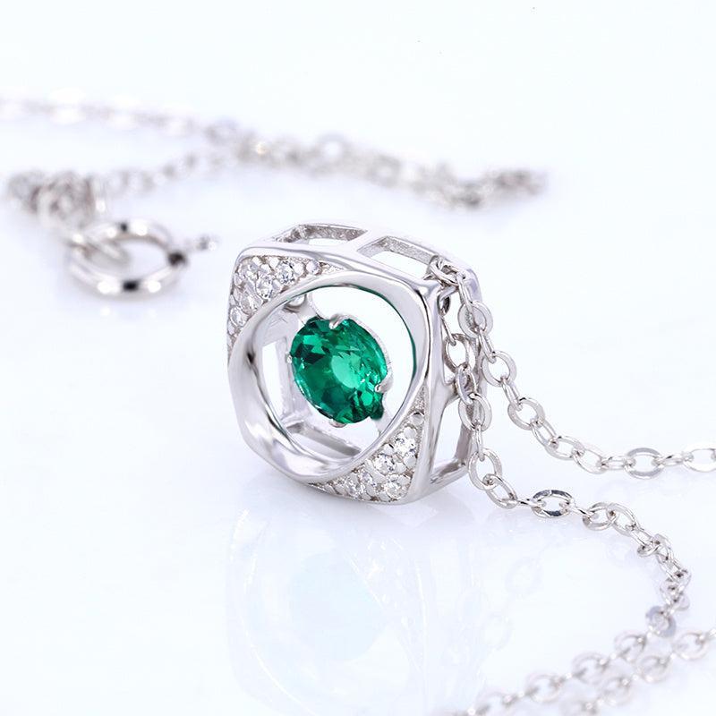 Silver necklace with a green gemstone on a white background