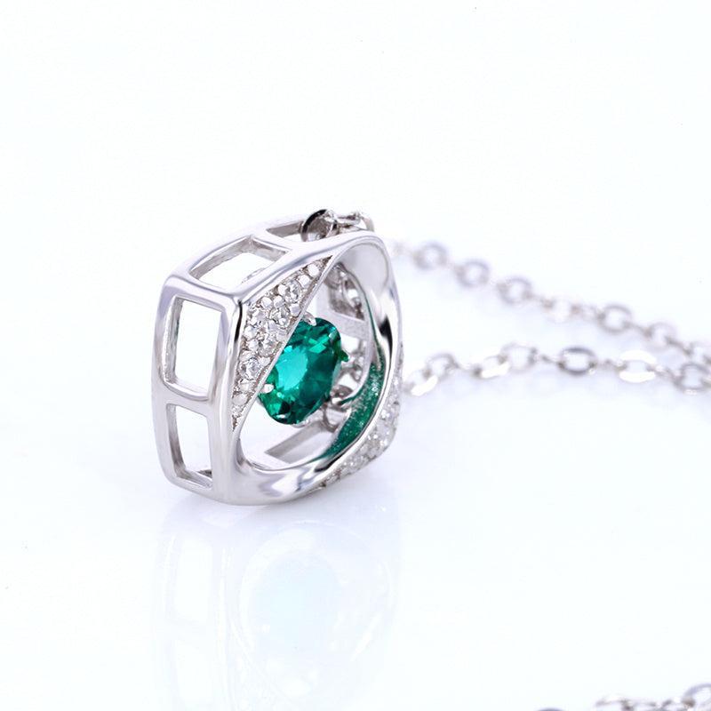 Silver necklace with a green gemstone on a white background